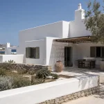 Σύγχρονη λευκή κατοικία με ασβεστωμένες επιφάνειες δίπλα στη θάλασσα